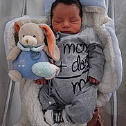 Malik participe au concours pour gagner de l'argent avec cette photo : baby, newborn, sleeping, plush_toy, stuffed_animal, onesie, baby_carrier, blanket, soft_toy, cuddly, infant, cute, cozy, child, face, resting, indoors, toy, peaceful, clothing