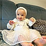 Darya participe au concours pour gagner de l'argent avec cette photo : baby, blanket, child, clothing, couch, cute, feet, happy, headband, home, indoors, infant, person, pillow, playful, portrait, sitting, smiling, white_dress, young_child