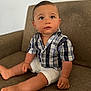 toddler, child, baby, plaid_shirt, white_shorts, couch, furniture, indoor, sitting, curious, looking_up, barefoot, shorts, young_child, person, cute, portrait, casual_clothing, human, skin