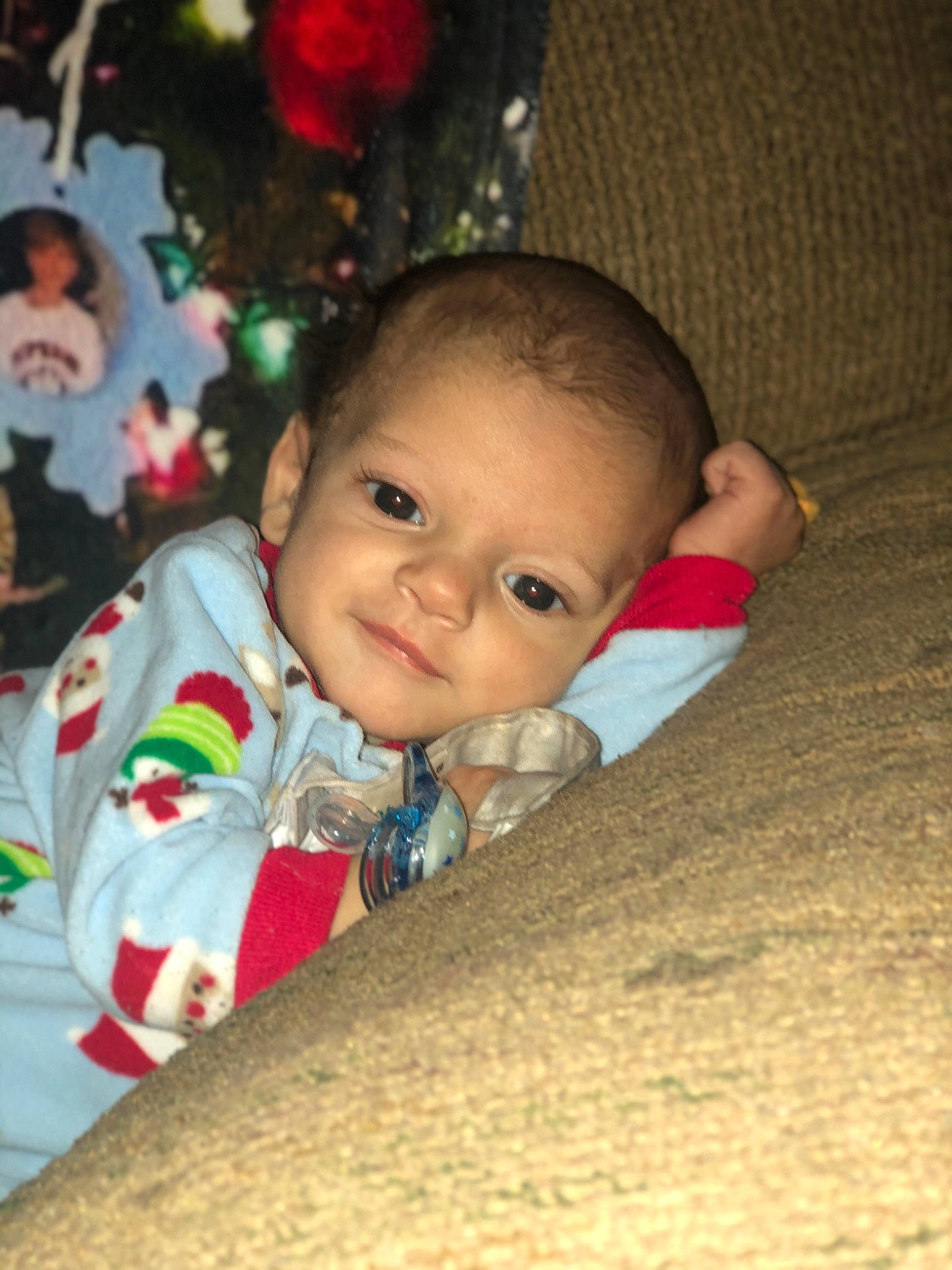 Gabriel is registered to the contest to win money with this photo: baby, baby_toddler_clothing, blurred, carmine, cheek, child, christmas, christmas_decoration, christmas_eve, christmas_ornament, christmas_tree, eye, holiday, holiday_ornament, nose, ornament, person, skin, toddler, tummy_time