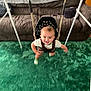 toddler, child, swing, indoor, carpet, couch, smiling, happy, clothing, person, furniture, baby, play, toy, home, room, green, brown, seat, fun