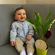 Ismael a rejoint le concours — aidez-le/la à gagner de superbes lots ! baby, child, smiling, sitting, couch, plant, green_pot, flower, indoor, milestone, 7_months, clothing, white_socks, happy, portrait, cute, young_child, home, decor, infant