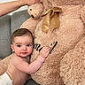 Ismael a rejoint le concours — aidez-le/la à gagner de superbes lots ! baby, diaper, teddy_bear, stuffed_animal, couch, hand, plush, child, infant, smiling, cute, soft, golden_bow, furniture, indoor, cozy, happy, skin, portrait, toy