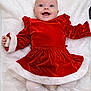 baby, celebration, child, christmas_outfit, cozy, cute, festive, happy, holiday, infant, lying_down, portrait, red_dress, smiling, soft_texture, toddler, velvet, white_blanket, white_socks, white_trim
