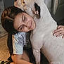Luna joined the competition — help win amazing prizes! girl, dog, hugging, affection, indoor, smiling, white_dog, casual_clothing, long_hair, comfort, friendship, pet, love, human_animal_interaction, floor, sitting, black_socks, tie_dye_shirt, gentle, closeup