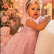 Katherine is registered to the contest to win money with this photo: toddler, child, dress, pink, headband, bow, toy, flower_arrangement, fairy_lights, birthday, celebration, teddy_bear, curly_hair, portrait, indoor, soft_lighting, decor, cute, smiling, happy