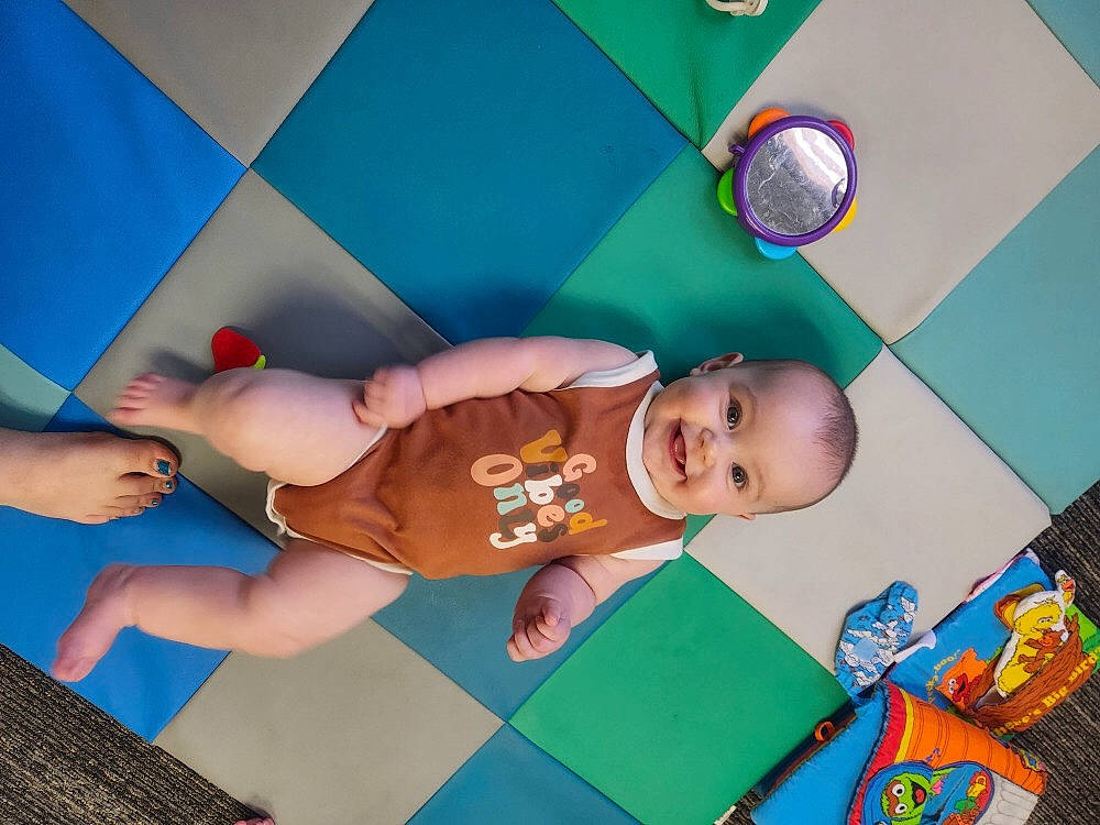 Aliyah is registered to the contest to win money with this photo: art, baby, baby_products, baby_toddler_clothing, baby_toys, child, flooring, fun, happy, human_leg, illustration, joy, knee, leisure, pattern, person, play, playmat, room, thigh