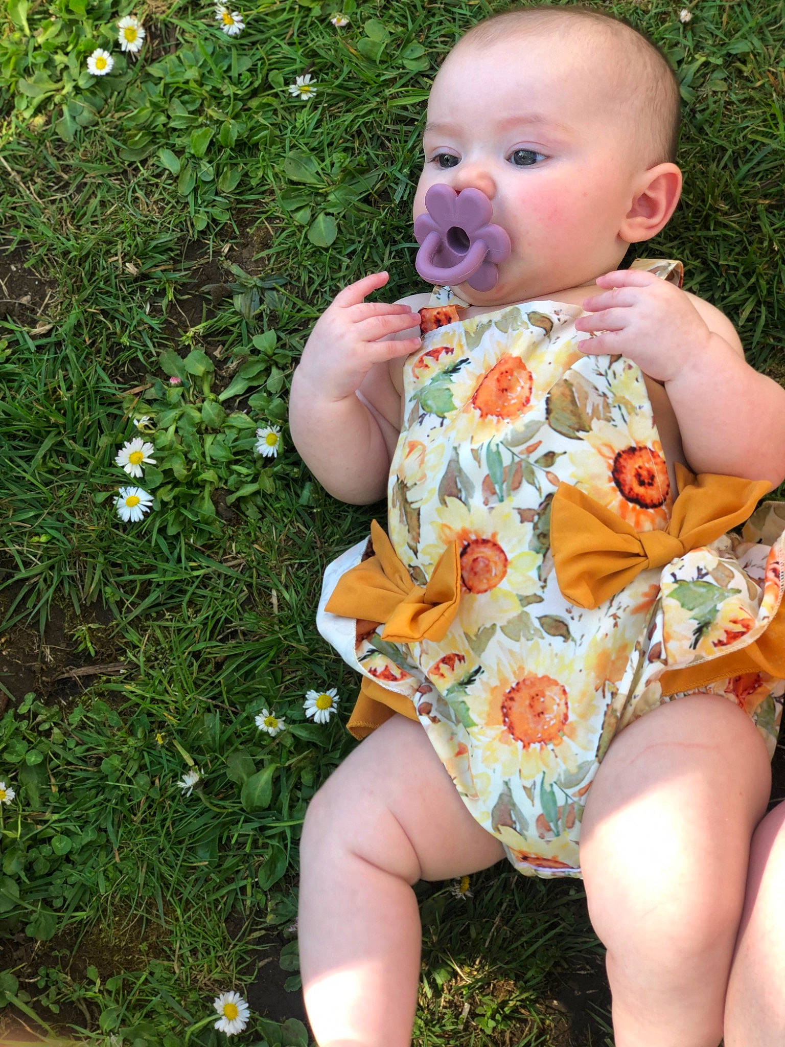 Aliyah is registered to the contest to win money with this photo: baby, baby_toddler_clothing, botany, cheek, dress, eye, facial_expression, finger, grass, grass_family, happy, head, iris, leaf, lip, people_in_nature, person, plant, skin, thigh