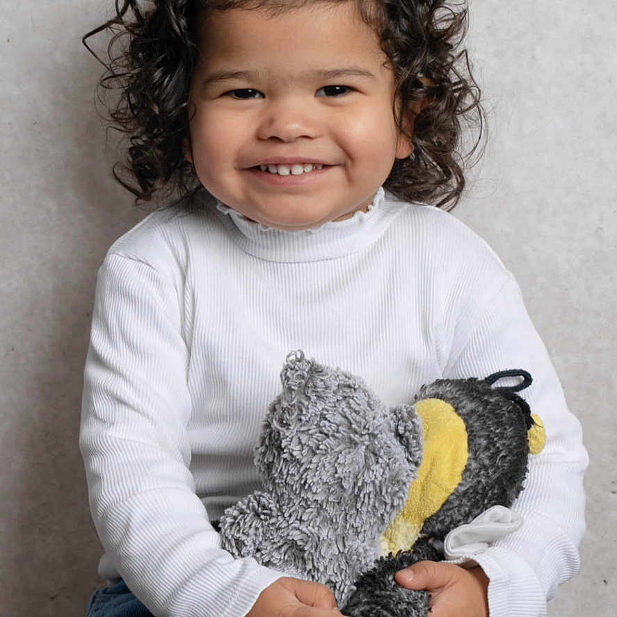 Lola a rejoint le concours — aidez-le/la à gagner de superbes lots ! baby, blue_jeans, child, cuddly_toy, curly_hair, cute, hair_clip, happy, hugging, indoors, person, plush_toy, portrait, sitting, smiling, studio_photo, stuffed_animal, toddler, white_shirt, young_child