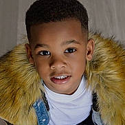 Samir is registered to the contest to win money with this photo: child, boy, portrait, face, smile, denim_jacket, fur_collar, fashion, young, cute, looking_up, black_hair, casual_clothing, indoors, person, head_and_shoulders, happy, warm_clothing, closeup, eyes