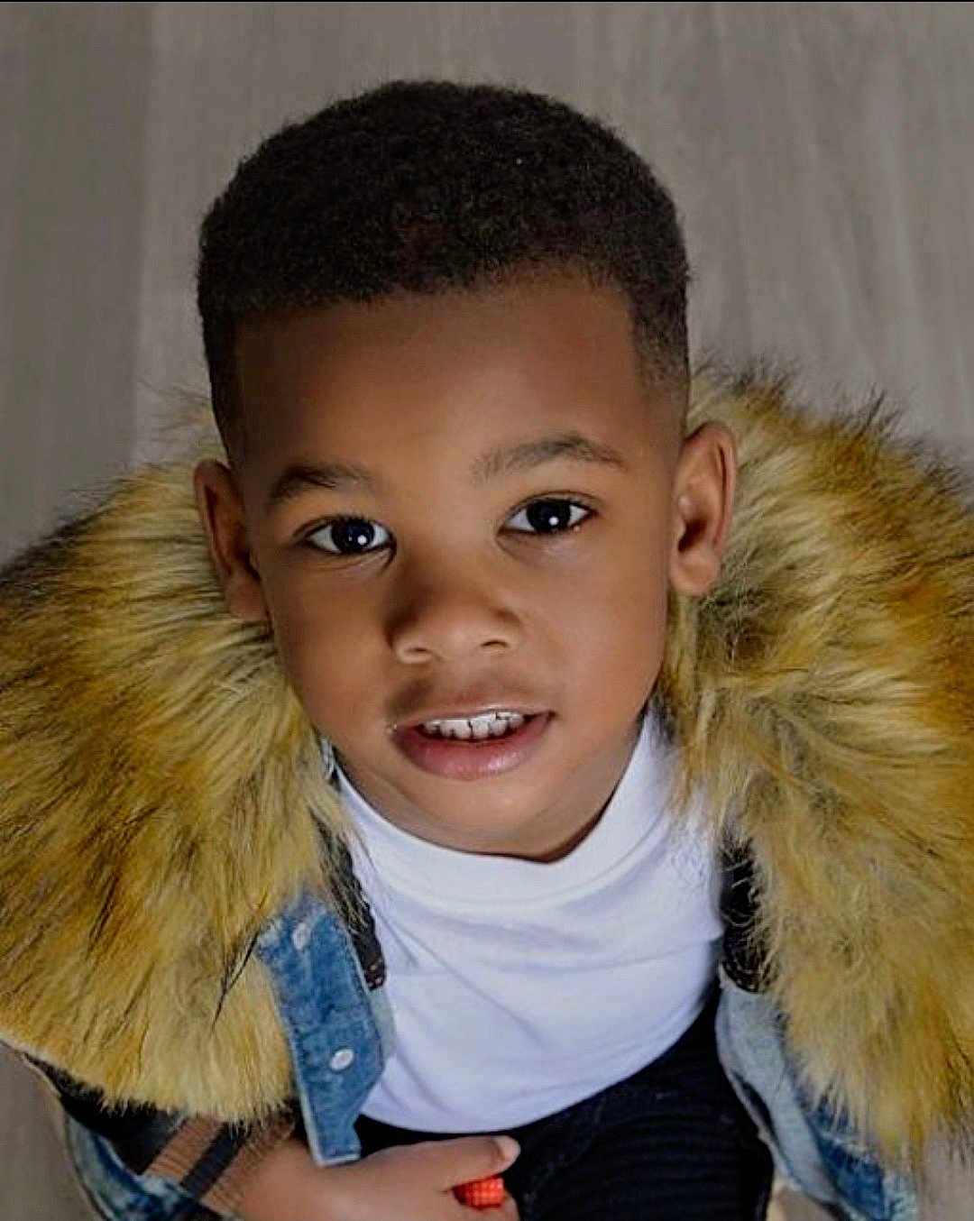 Samir is registered to the contest to win money with this photo: child, boy, portrait, face, smile, denim_jacket, fur_collar, fashion, young, cute, looking_up, black_hair, casual_clothing, indoors, person, head_and_shoulders, happy, warm_clothing, closeup, eyes