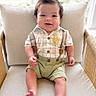 baby, child, smiling, sitting, indoors, chair, cushion, clothing, suspenders, shorts, hairstyle, window, natural_light, cute, portrait, feet, happy, person, infant, home