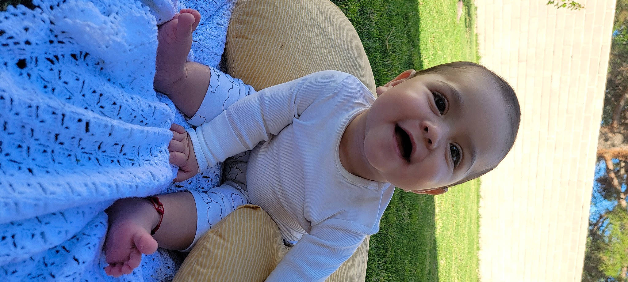 Lauro is registered to the contest to win money with this photo: baby, baby_toddler_clothing, child, comfort, facial_expression, finger, gesture, grass, hand, happy, human, human_body, joint, leg, people_in_nature, person, plant, product, skin, smile