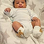 Kairi is registered to the contest to win money with this photo: baby, infant, blanket, white_onesie, socks, bear_socks, star_pattern, cozy, soft, cute, child, newborn, resting, indoors, portrait, skin, face, hands, feet, lying_down