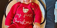 Kairi joined the competition — help win amazing prizes! baby, infant, smiling, red_clothing, knitwear, hat, christmas, holiday, cute, face, person, child, indoor, seat, cushion, white, black, cozy, festive, portrait