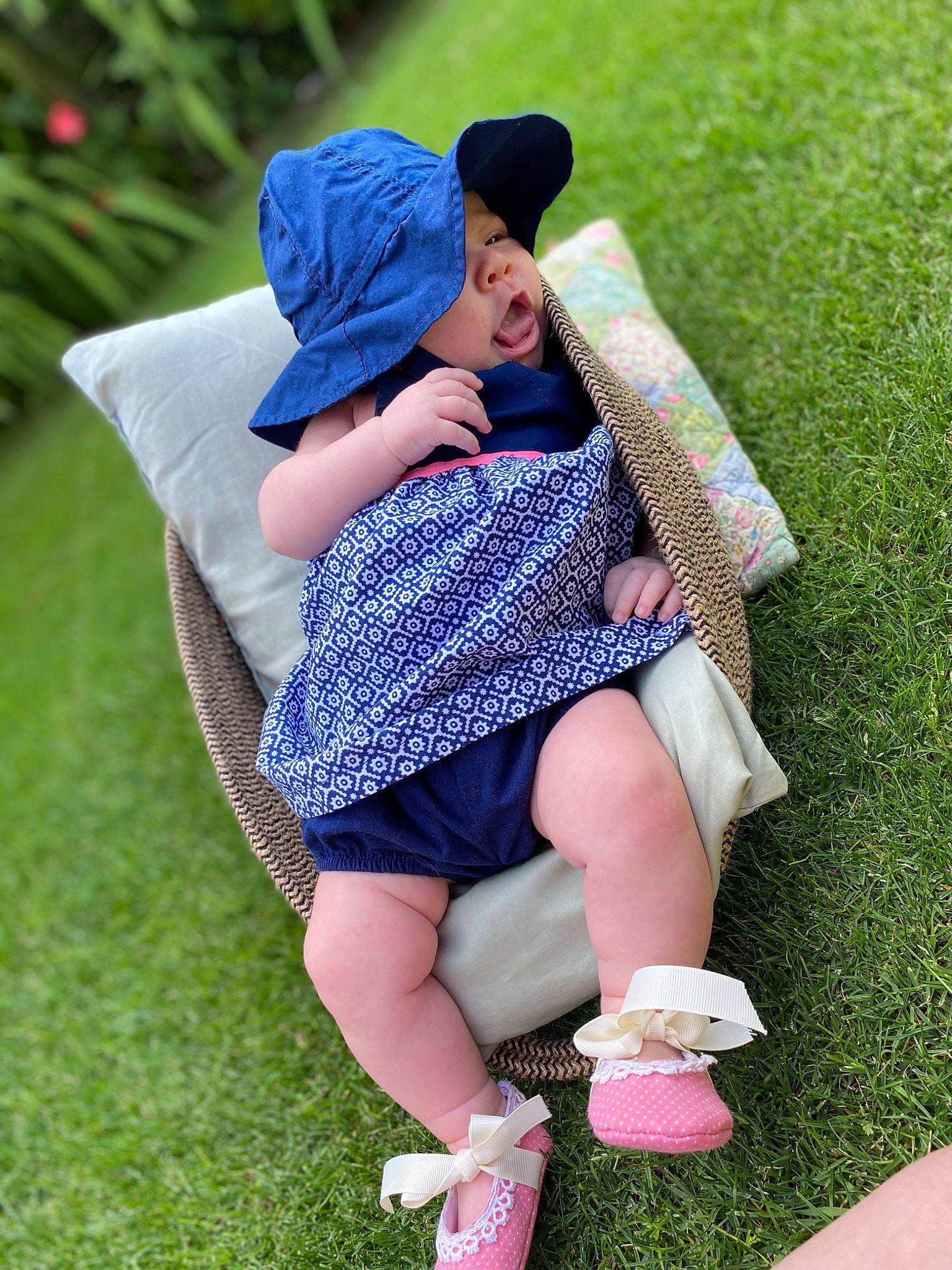 Joann is registered to the contest to win money with this photo: beauty, blue, child, footwear, grass, grass_family, green, headgear, headwear, human_leg, interaction, lawn, leg, leisure, person, pink, sitting, skin, spring, summer