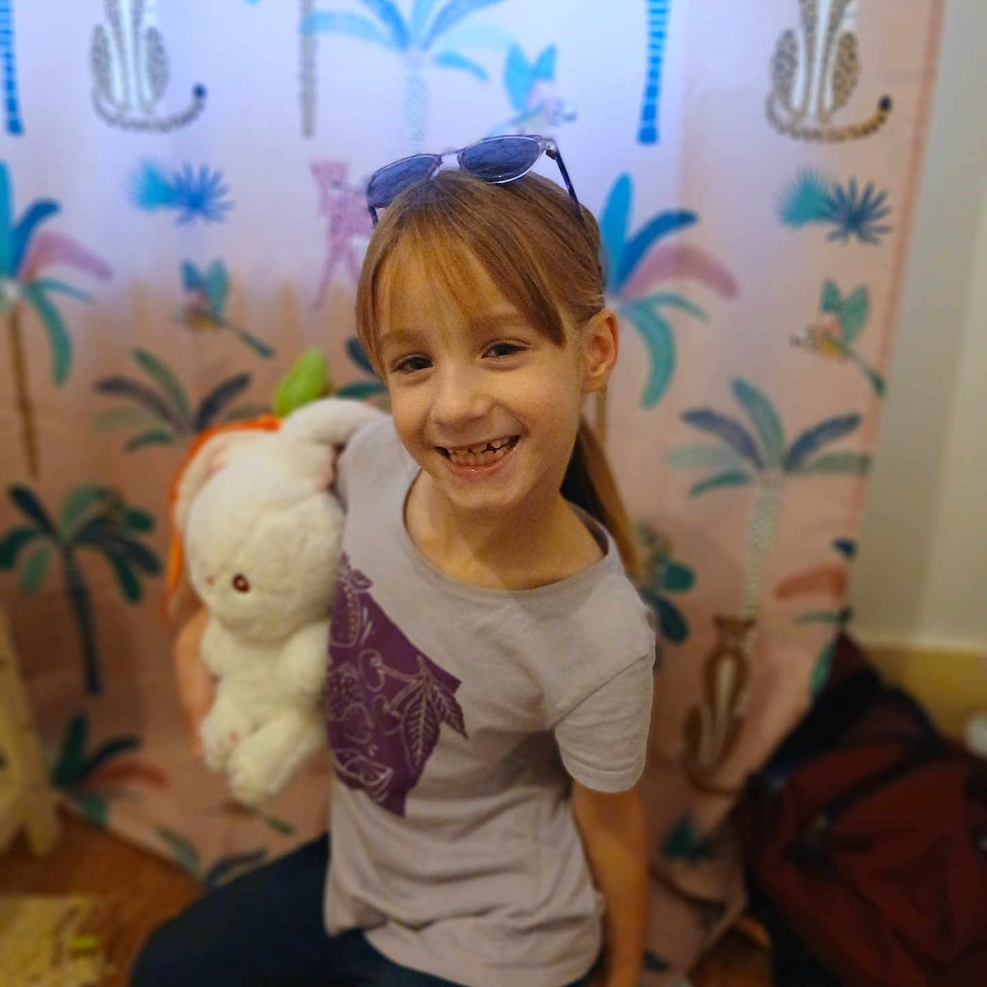 Maelys participe au concours pour gagner de l'argent avec cette photo : accessories, child, clothing, couch, face, female, furniture, girl, glasses, happy, head, jeans, pants, person, photography, plush, portrait, t_shirt, toy, wood