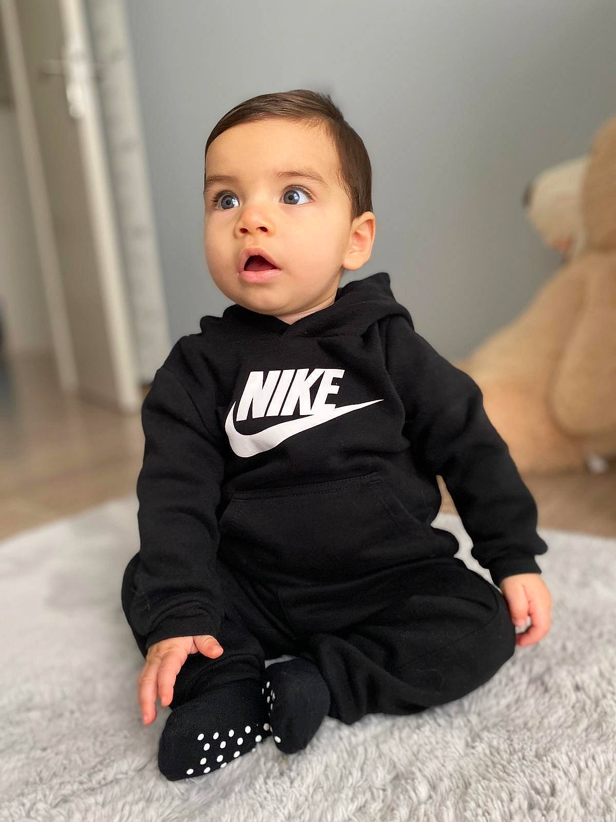 Yusuf participe au concours pour gagner de l'argent avec cette photo : baby, baby_toddler_clothing, cheek, child, comfort, flash_photography, floor, flooring, fur, happy, head, human_leg, knee, leg, person, sitting, skin, sleeve, t_shirt, toddler