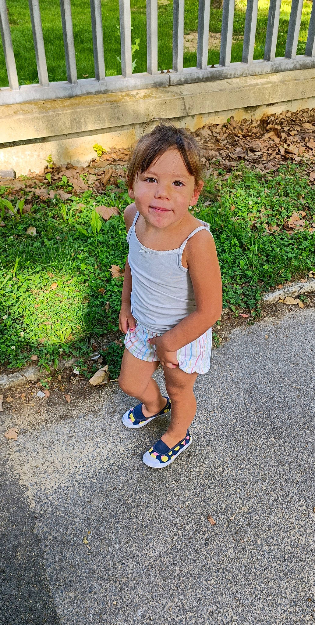 Maeva a rejoint le concours — aidez-le/la à gagner de superbes lots ! asphalt, baby_toddler_clothing, child, electric_blue, face, fun, grass, happy, human_leg, joy, leisure, people_in_nature, person, plant, road_surface, shorts, sitting, sleeve, t_shirt, thigh