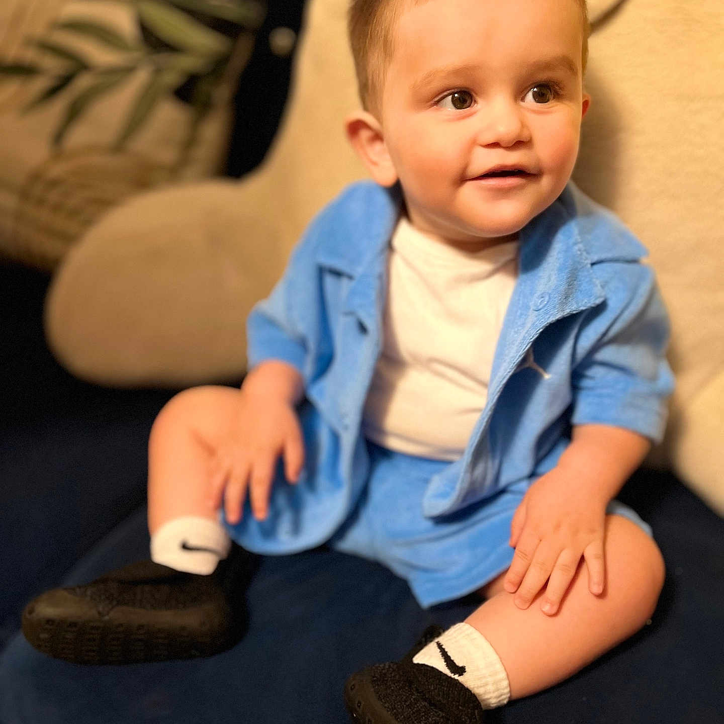 Jeishiel is registered to the contest to win money with this photo: black_shoes, blue_outfit, child, couch, cozy, curious, face, furniture, hands, happy, home, indoor, portrait, seated, short_hair, smiling, soft_lighting, toddler, white_shirt, white_socks