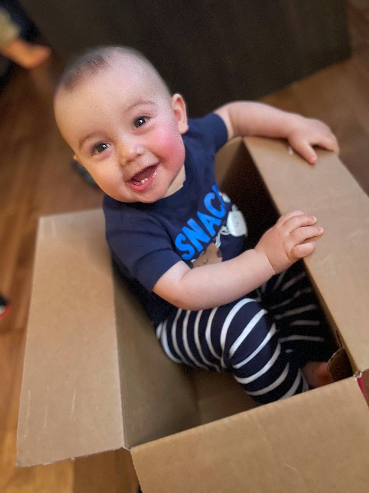 Loukas a rejoint le concours — aidez-le/la à gagner de superbes lots ! baby, baby_toddler_clothing, chair, child, electric_blue, floor, flooring, fun, happy, hardwood, person, room, shorts, sitting, sleeve, smile, stairs, t_shirt, table, toddler