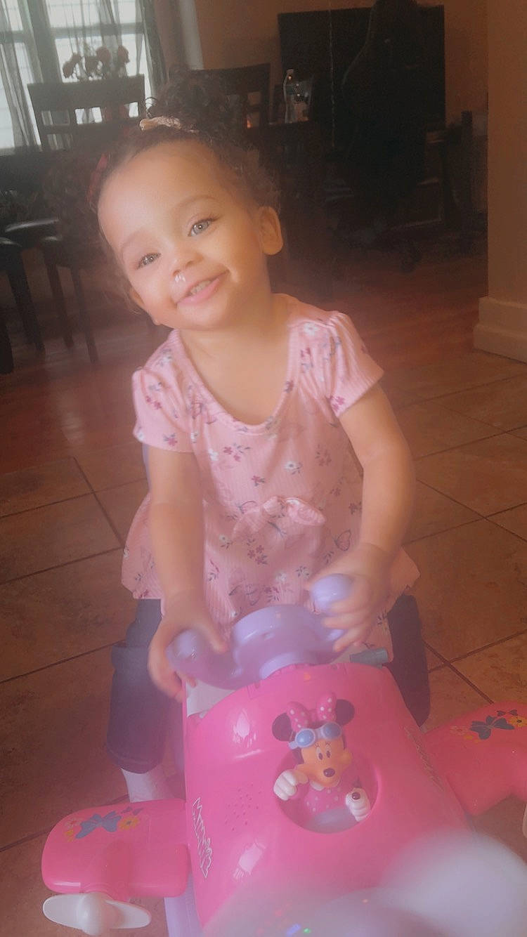 Zariyah is registered to the contest to win money with this photo: baby, baby_toddler_clothing, child, floor, flooring, fun, happy, hardwood, joy, magenta, mammal, person, pink, plastic, play, sitting, skin, smile, toddler, toy