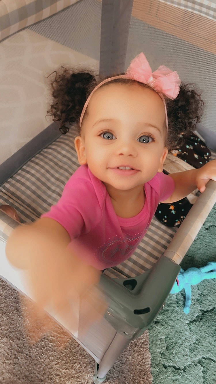 Zariyah is registered to the contest to win money with this photo: arm, baby, baby_toddler_clothing, cheek, chin, eye, eyelash, facial_expression, finger, hand, happy, head, human_body, iris, joy, lip, nose, person, pink, skin