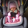 Jewlez is registered to the contest to win money with this photo: baby, infant, sleeping, car_seat, pink_clothing, gray_car_seat, hat, pacifier, harness, seat_belt, portrait, indoors, cozy, peaceful, resting, child, face, textile, safety_labels, transportation