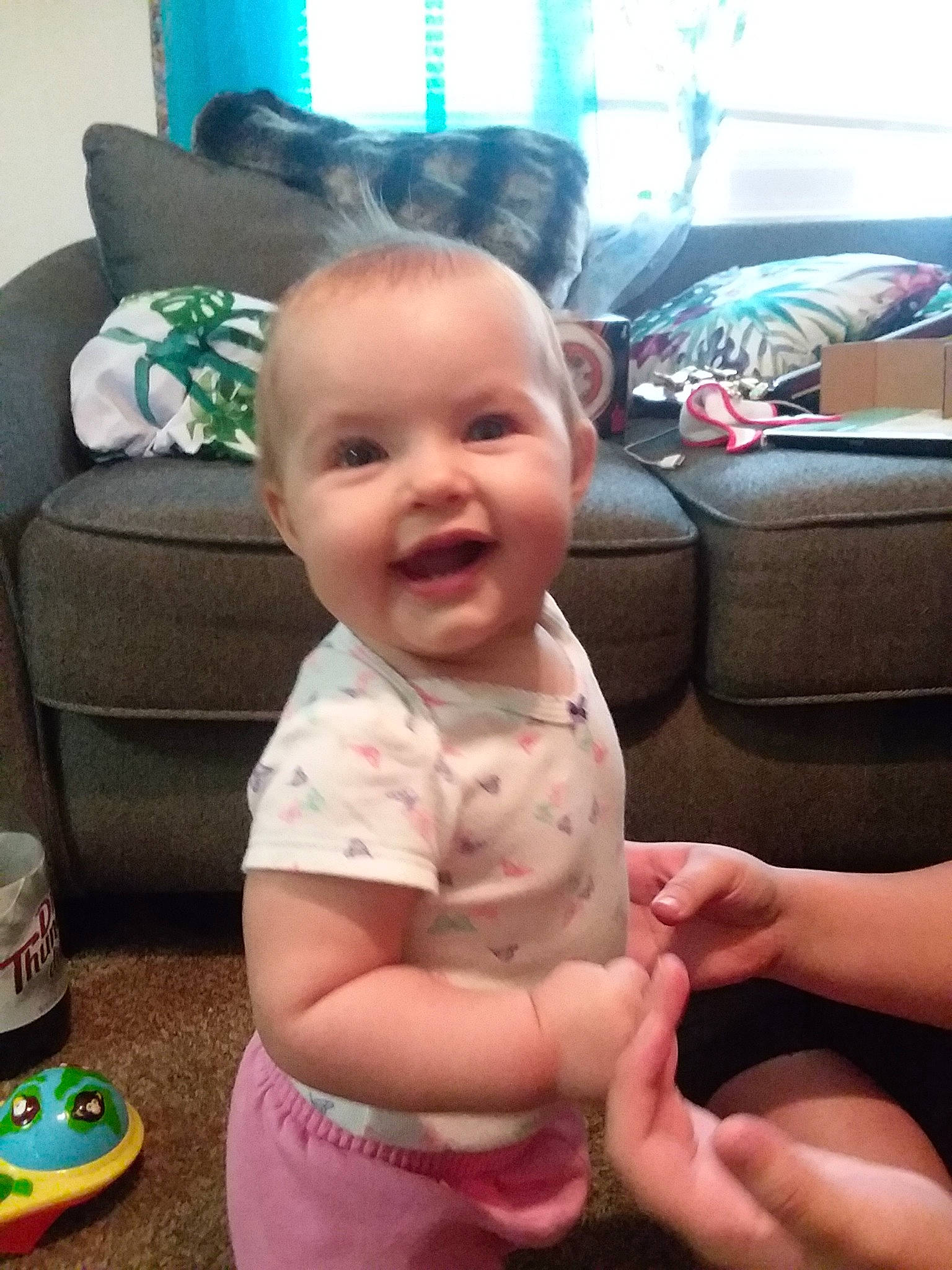 Alise is registered to the contest to win money with this photo: baby, cheek, child, cool, ear, electronic_device, face, finger, head, leg, person, sitting, skin, smile, thumb, toddler