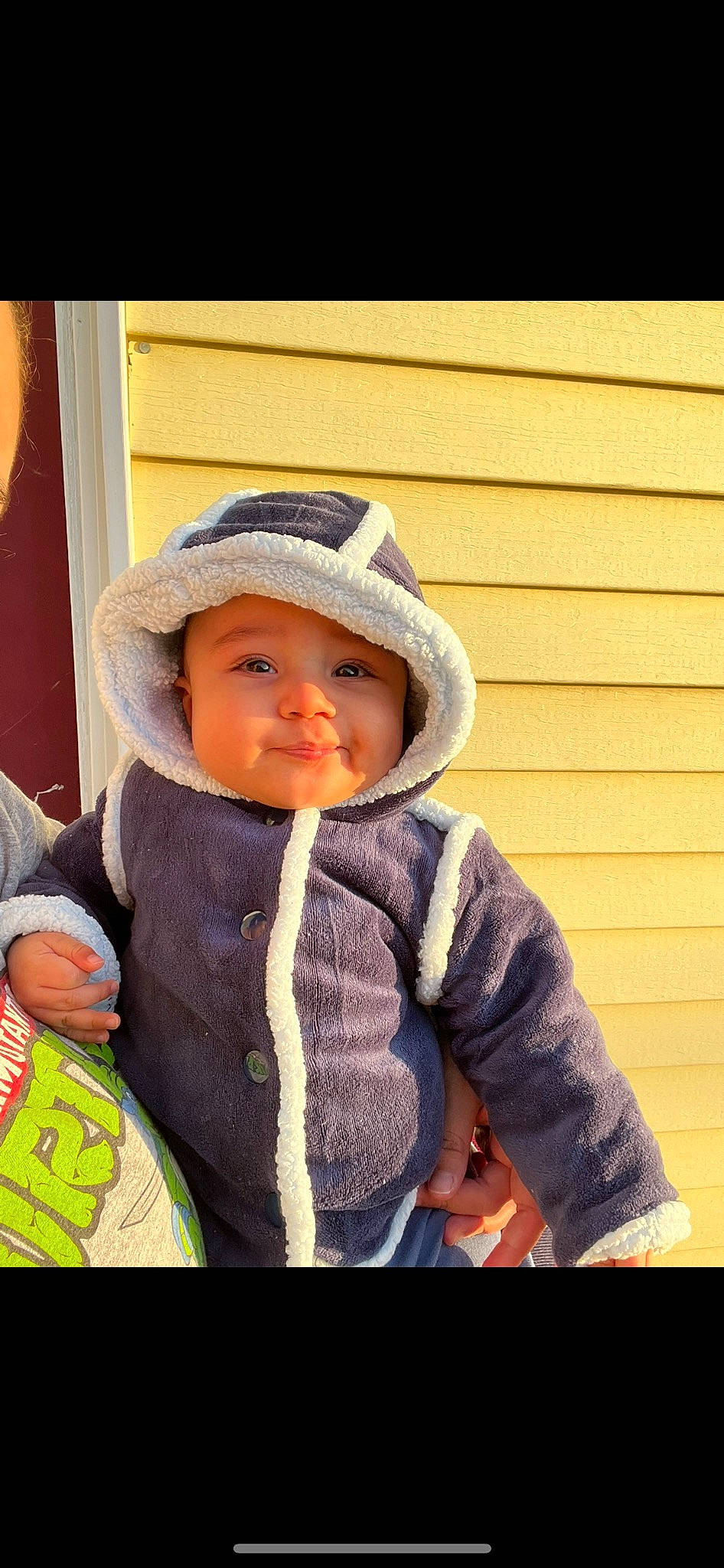 Abraham joined the competition — help win amazing prizes! baby, baby_products, baby_toddler_clothing, cap, cheek, child, face, fashion_accessory, happy, headgear, headwear, hoodie, person, personal_protective_equipment, sitting, sleeve, smile, toddler, winter, wood