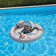 Mattéo participe au concours pour gagner de l'argent avec cette photo : baby, blue_water, child, floating, fun, happy, inflatable_ring, leisure, outdoor, playful, recreation, safety, summer, sun_hat, sunny, swim_shirt, swimming, swimming_pool, toddler, water