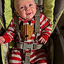 baby, infant, smiling, striped_pajamas, reindeer_slippers, onesie, baby_seat, safety_harness, seat_buckle, portrait, cute, hands, feet, indoor, cushion, fabric, holiday_outfit, young_child, happy, person