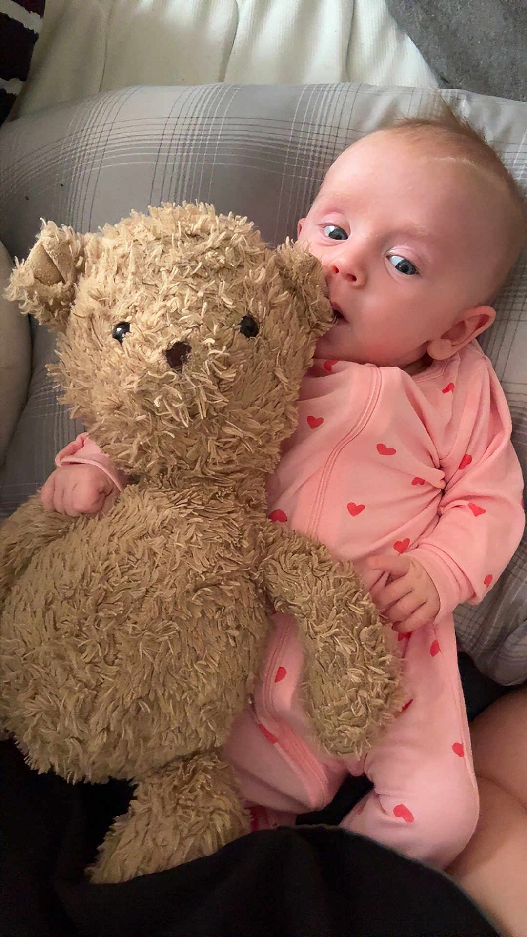 Emma joined the competition — help win amazing prizes! baby, infant, teddy_bear, stuffed_animal, pink_outfit, hearts, blanket, pillow, cute, portrait, lying_down, soft_toy, sleepwear, plush, one_person, face, eyes, hand, cuddling, bedroom