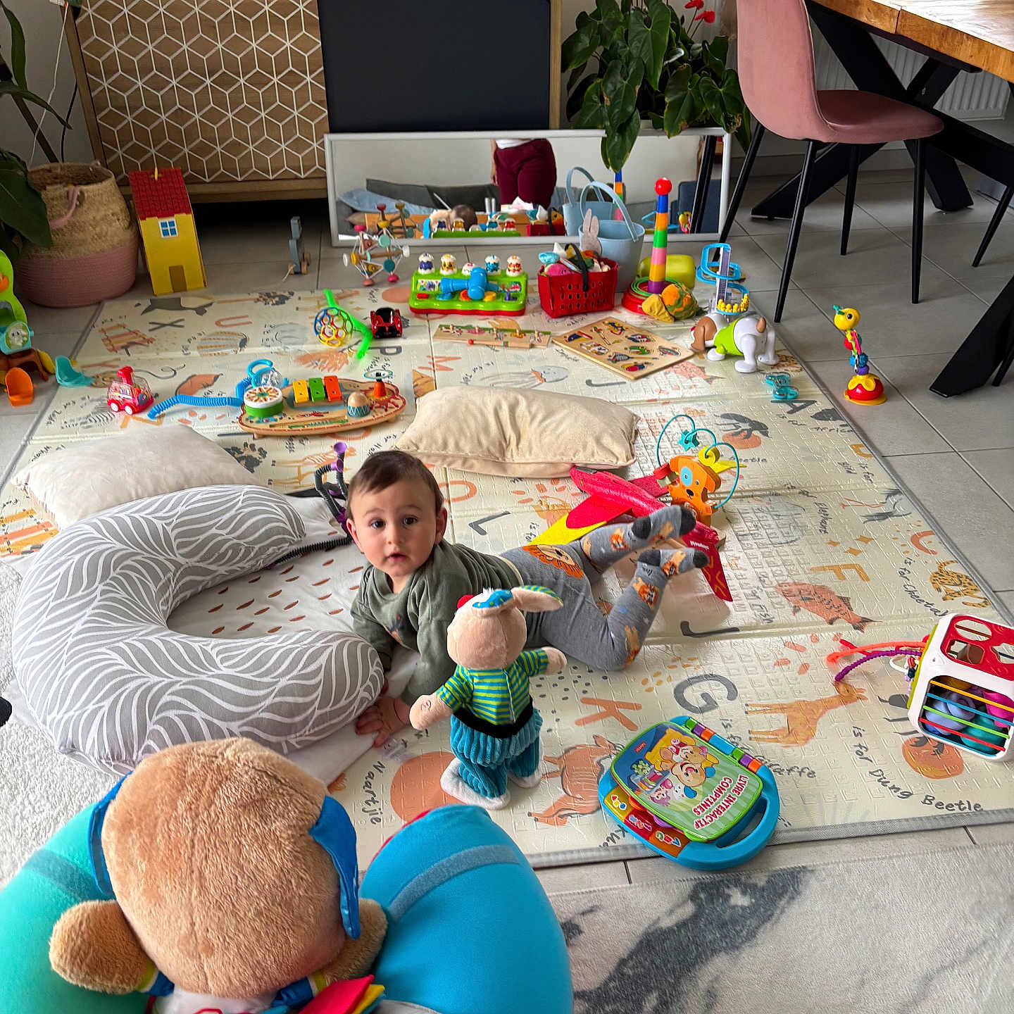 Rihan Nils a rejoint le concours — aidez-le/la à gagner de superbes lots ! baby, child, toy, playmat, cushion, living_room, plant, furniture, floor, colorful, indoor, child_playing, mirror, puzzle, chair, table, window, book, stuffed_animal, decor