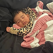 Zaylie joined the competition — help win amazing prizes! baby, sleeping, blanket, leopard_print, cozy, infant, child, black_background, soft_texture, resting, cute, peaceful, earring, pink, white, striped_blanket, face, clothing, portrait, comfort