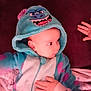 baby, child, hoodie, costume, blue, monster, hand, indoor, soft, plush, cute, face, expression, clothing, person, infant, warm, sleeve, pink, blanket