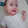 baby, infant, smiling, onesie, bed, striped_bed_sheet, pacifier, cute, cheeky, happy, lying_down, face, head, arm, child, clothing, indoor, person, newborn, expression