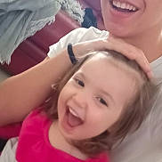 Wendy participe au concours pour gagner de l'argent avec cette photo : child, person, smile, laughing, indoor, couch, blanket, white_shirt, happy, family, sibling, living_room, cozy, casual, young, joy, playful, cute, tiled_floor, hand