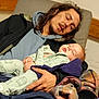 Kemp is registered to the contest to win money with this photo: adult, baby, sleeping, blanket, chair, clothing, cozy, face, hand, indoor, jacket, long_hair, person, pajamas, peaceful, portrait, rest, seated, tired, young_child