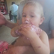 Kemp joined the competition — help win amazing prizes! toddler, child, cake, frosting, messy, hand, adult, person, indoor, seat, stool, vending_machine, coca_cola, food, eating, face, arm, casual_clothing, blurred_background, light