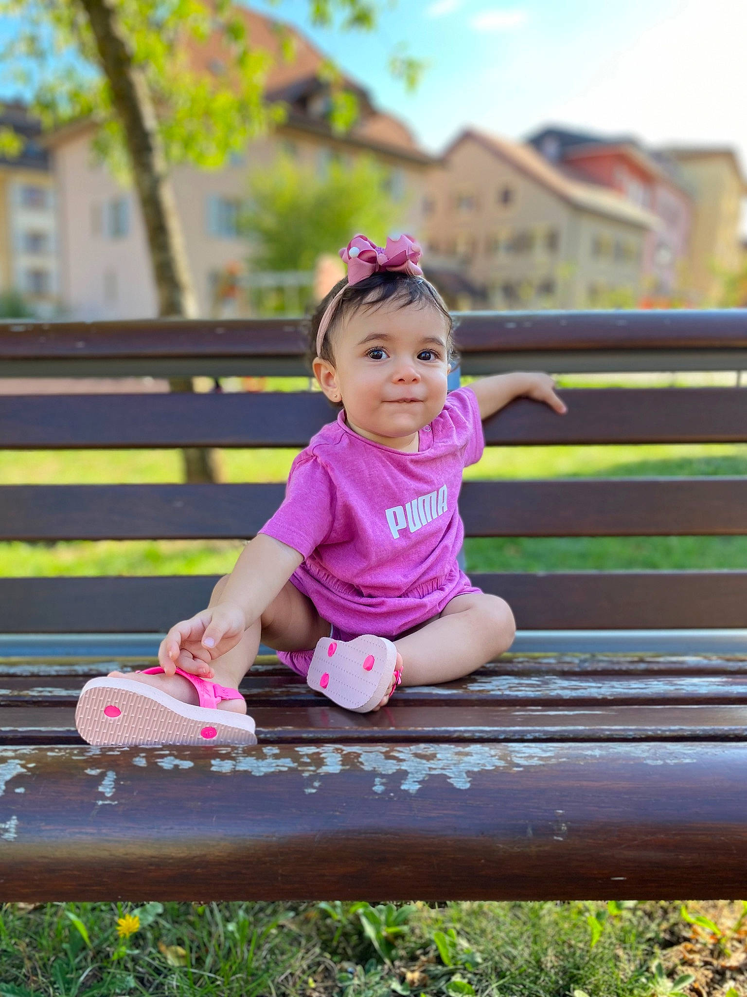 Ella May a rejoint le concours — aidez-le/la à gagner de superbes lots ! baby_toddler_clothing, child, face, fun, grass, happy, leaf, leisure, magenta, outdoor_bench, outdoor_furniture, people_in_nature, person, pink, recreation, sitting, sky, spring, toddler, tree
