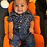 baby, child, smiling, blue_shirt, denim_shorts, orange_cushion, plush_star, plush_moon, seat, indoor, happy, person, cute, infant, portrait, clothing, furniture, wood_floor, sitting, young