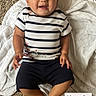 baby, child, infant, striped_clothing, hat, carpet, blanket, lying_down, cute, expression, person, indoors, feet, hands, smiling, clothing, portrait, adorable, young, face