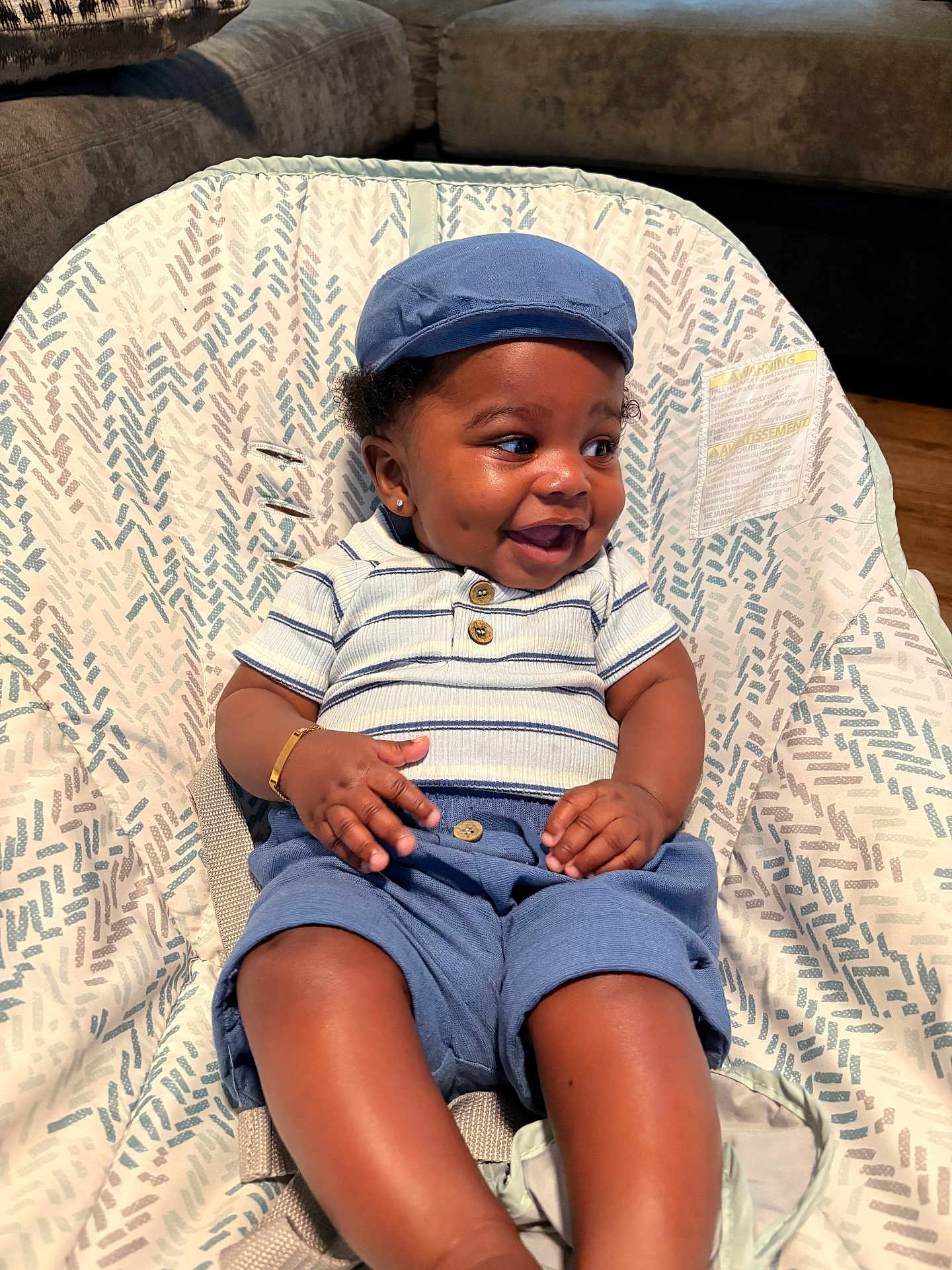 Royal Mize joined the competition — help win amazing prizes! baby, smiling, child, blue_cap, blue_shorts, striped_shirt, sitting, baby_seat, dimples, happy, indoor, bracelet, infant, cute, clothing, person, furniture, patterned_fabric, portrait, casual