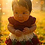 baby, bokeh, child, cute, dress, face, flower_pattern, garden, golden_hour, grass, hands, nature, outdoor, person, portrait, soft_focus, summer, sunlight, warm_light, young_child