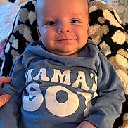 Joshua is registered to the contest to win money with this photo: baby, infant, smile, blue_clothing, onesie, blanket, patterned_blanket, hand, face, cute, happy, child, person, portrait, indoor, warm, cozy, newborn, soft, comfort