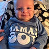 baby, infant, smile, blue_clothing, onesie, blanket, patterned_blanket, hand, face, cute, happy, child, person, portrait, indoor, warm, cozy, newborn, soft, comfort