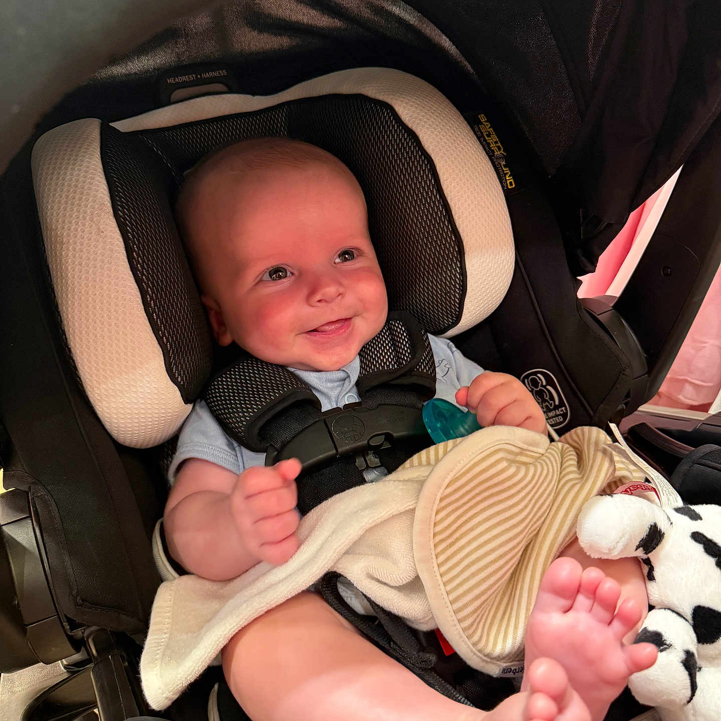 Joshua is registered to the contest to win money with this photo: baby, car_seat, smiling, infant, blanket, pacifier, plush_toy, foot, hand, headrest, harness, clothing, indoor, cute, child, safety, seat_belt, comfort, young_child, happy