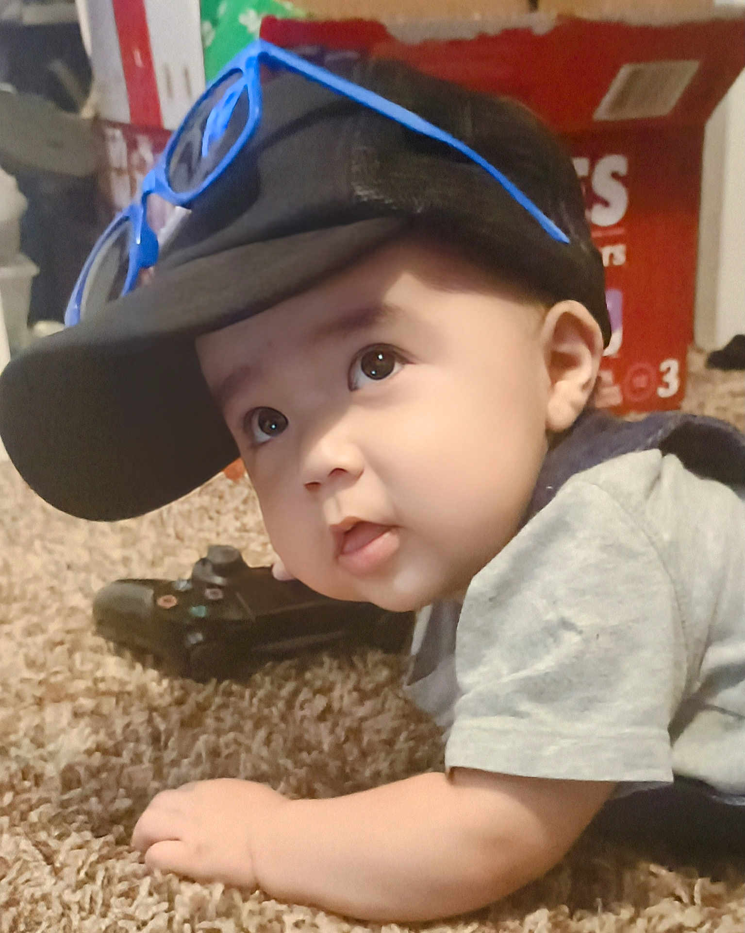 Jadiel joined the competition — help win amazing prizes! baby, child, cap, sunglasses, carpet, controller, gaming, toy, indoor, curious, face, person, crawling, clothing, hand, young, headwear, casual, cute, infant