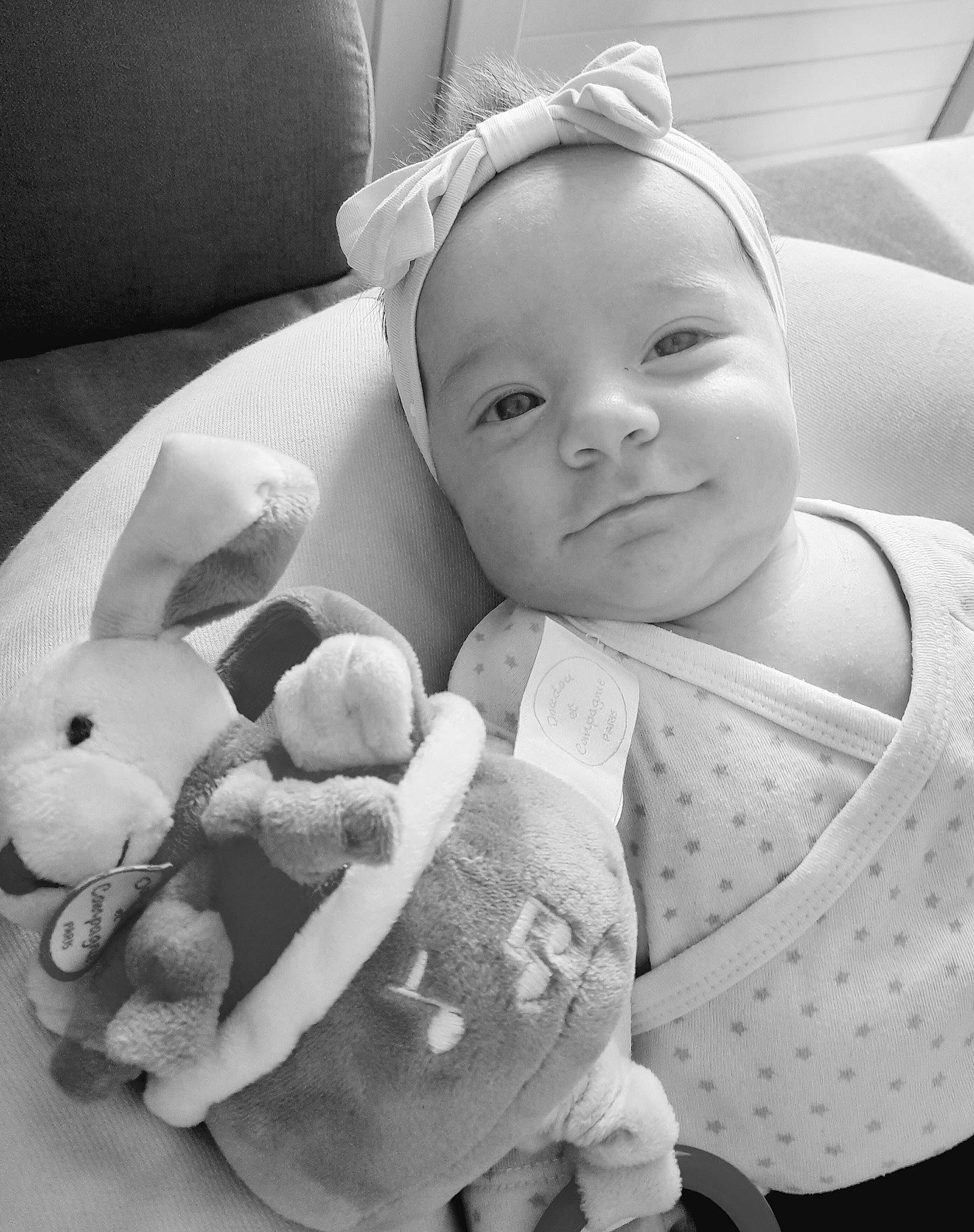 Eva participe au concours pour gagner de l'argent avec cette photo : arm, baby, baby_products, baby_toddler_clothing, black, black_and_white, cheek, child, comfort, eye, happy, iris, lip, monochrome_photography, person, product, skin, smile, textile, toddler